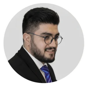 پرترهٔ دکتر مسعود وصالان با کت رسمی، کراوات آبی و عینک