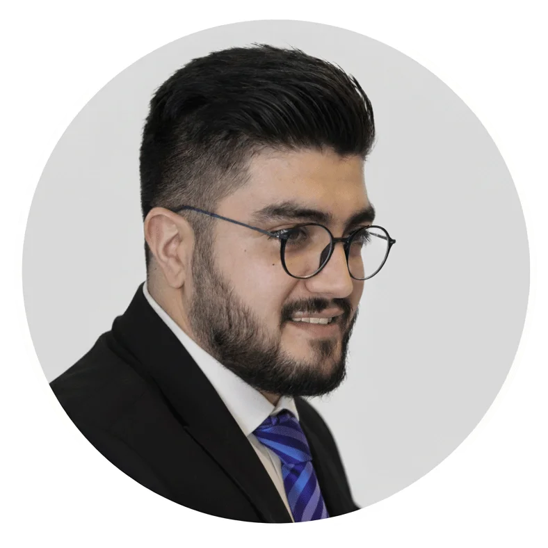 پرترهٔ دکتر مسعود وصالان با کت رسمی، کراوات آبی و عینک